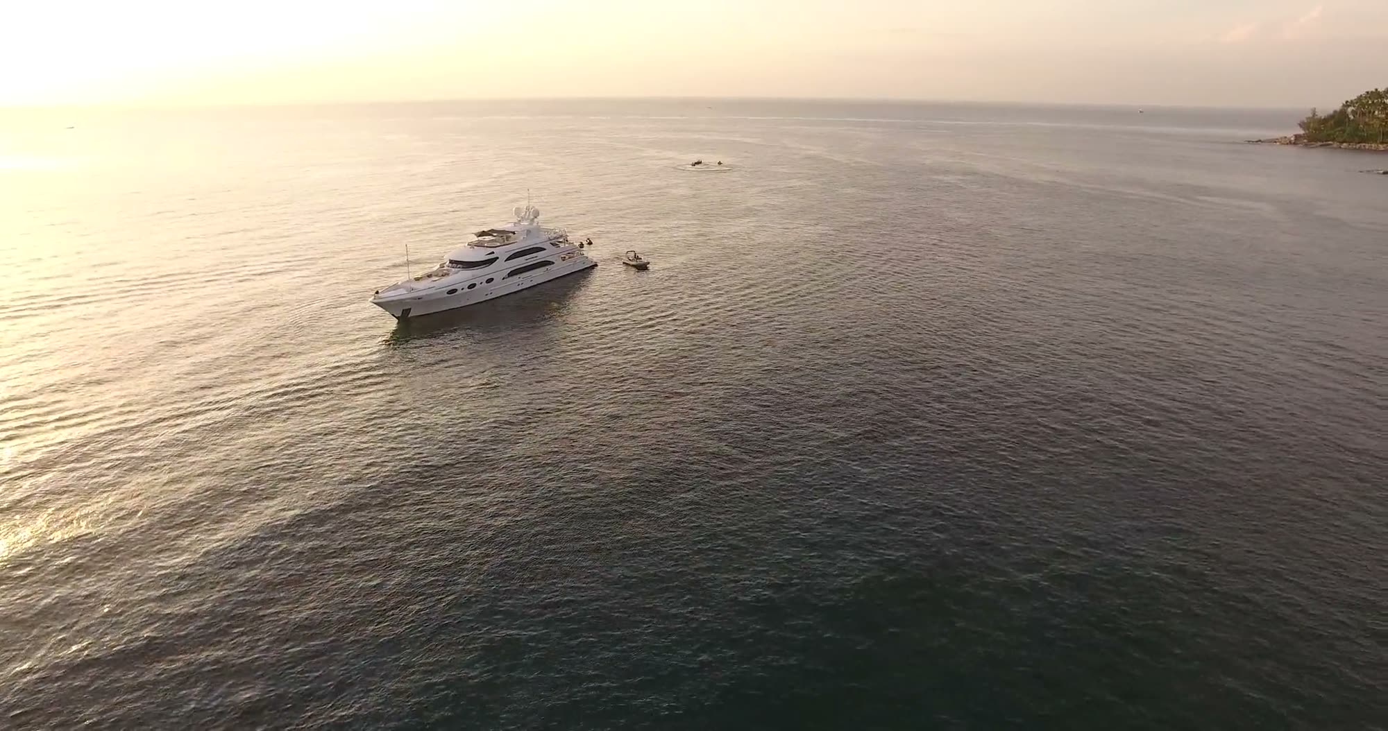 A yacht at anchor on a calm sea at golden hour